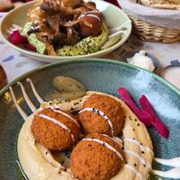 Classic hummus and falafel, and basil hummus with mushrooms, kibbeh and cauliflower in the background at The Hummus Connection  in Nuremberg