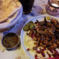 Baba ganoush topped with oyster mushroom shawarma and batata harra and zhoug dip. at The Hummus Connection  in Nuremberg
