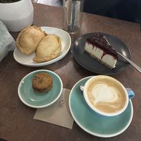 Dos empanadas, frutas rojo cheesecake, un café y little cookie sandwich  at La Loca de Enfrente in Madrid