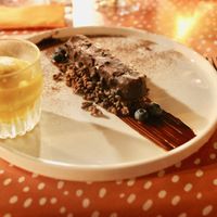 Een huisgemaakte hazelnoot ijsreep.

Omhuld met pure chocolade en nootjes. Geserveerd op chocolade-koffie rice krispies + huisbemaakte mango sorbet
 at Zus en Zo in Bocholt