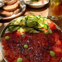 Tomatoes carpaccio and hummus  at Meshek Barzilay in Tel Aviv