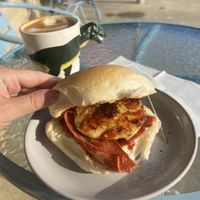 The ‘Peter Dinklage’ vegan egg and bacon roll with tomato sauce. Piping hot soy flat white    at The Cove in Lakes Entrance