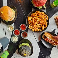 Chicken burger (the pink one), truffle burger (the black one), cheeseburger and coloured hotdog + curly fries + 4 sauces (bbq & garlic are the best) at Vegan Pirates by CloudEatery in Berlin