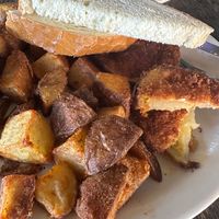 What they brought me as the “vegan eggs benedict”- two slices of over fried yellow tomatoes, potatoes, and plain white bread with no jam or anything. at Cedar Point Bar and Kitchen in Philadelphia