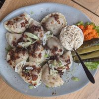 Mix of savory pierogi: chilli sin carne and smoked tofu, with fried onions, vegan sour cream, shredded carrot, and dill pickles on the side at Kemuri in Reykjavik