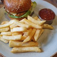 Garden Vegetable Burger: Garden vegetable & grain burger pattie topped with oven roasted peppers. Served with chips & smoky tomato chutney (added slice of vegan cheese) at De Trafford Arms Hotel in Alderley Edge