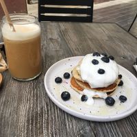 Oat pancakes with blueberries and coconut yoghurt. Oat milk iced latte on the side.   at Berguna Gluten Free in Valencia