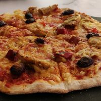 Vegan pizza, "la fabuleuse", tomato sauce, marinated peppers, kalamata olives, aiguillettes (Happyvore) and vegetable rapé, espelette pepper at La Pizza de Nico in Paris