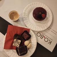 Cheesecake, 3 smaller cakes (raspberry chocolate, italian milk cake and triple chocolate), free biscuit and a espresso macchiato. at Ko.bo Vegan in Milan
