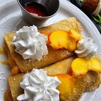 peaches & cream crepes - vegan crepes, cooked peach filling & fresh peach topping, vegan whipped cream, maple syrup, powdered sugar at Mad Rabbit Cafe in Madison