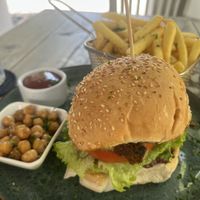 Cauliflower burger with all the fixings including black olive tapenade and hummus. Generous portion of fries!  at Isabelle Off The Beach in Westpunt