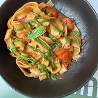 Tagliatelle pasta with tomatoes and green pesto - vegan  at Ecooking in Milan