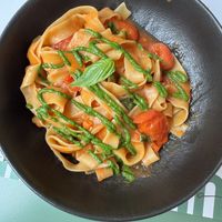 Tagliatelle pasta with tomatoes and green pesto - vegan  at Ecooking in Milan