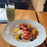 A bowl of oatmeal and a iced matcha latte. at Moment in Prague