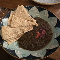 Flame Charred tomato choka dip with roti  at Shado Beni Caribbean Tapas Lounge in Caye Caulker