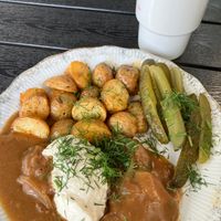 Soy cutlets in sauce (front), homemade compote with fresh fruit (back) at Vegan Friends Kitchen in Warsaw