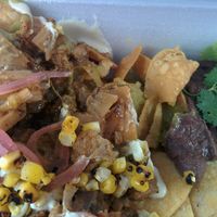 Chilaquiles : smoked,  pulled jackfruit sauteed with housemade salsa verde, poblano peppers, red onion & spinach, served over crispy housemade corn chips with cashew ‘crema’, red onion and roasted corn and creamy black beans   at Verdine - Food Truck in Houston