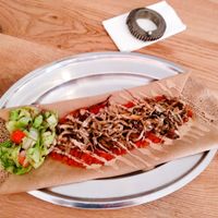 mushroom dish with tahini and spicy tomato sauce, served over injera bread at Tenat at Tenat in Tel Aviv