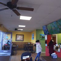 Inside the dining area. You can see the menu takes up fully two large flat screens, plus a smaller acreen and there's a whiteboard for desserts! at El Cantaro Vegan Mexican Restaurant in Monterey