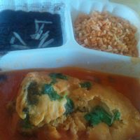 Chile relleno, stuffed with cheese in tomato sauce, with sides of rice, and black beans at El Cantaro Vegan Mexican Restaurant in Monterey