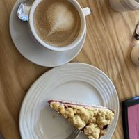Flat white with oat milk and a piece of raspberry apple cake  at Café Wohnzimmer in Karlsruhe
