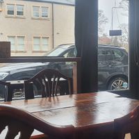 Wooden tables and the view through the front window of the cafe at The Kitchen Treasury in Kirkcaldy