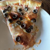 Slice of vegan pizza with vegan pepperoni and black olives   at Damn Fine Pizza in Port Orchard