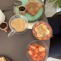 Smoothie bowl and heart shaped coffee with an almond butter pancake   at Akasha Metaphysical & Vegan Cafe in St Georges