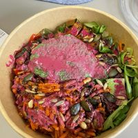 Bowl mit Kartoffelecken, veganer Currywurst, Möhrensalat, pinkes Tahin Dressing und Erbsen-Hanf-Dip  at boool in Dinslaken