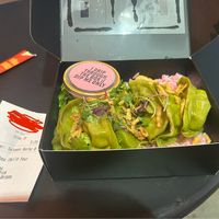 Veggie dumplings on greens and pink rice, topped with fried onions  at Lovebite in Phoenix