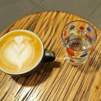 Oatmilk cappuccino, complimentary  water at 84th Brickyard in Hanoi