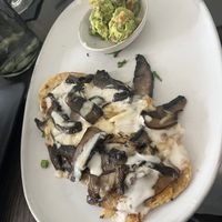 This Huarache Vegano. Hand formed corn tortilla, sautéed mushrooms, vegan sour cream, refried beans, guacamole    at Consuelo in Gainesville
