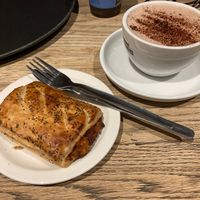 Vegan sausage roll and hot chocolate w foam at Caffè Nero - Excise Walk North Dock in Dublin