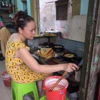 Lady frying pancakes at Quán Chay Ha in Da Nang