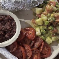Baked potatoe, avocado salad, beans and grilled tomatoes  at Eva's Cafe and Bar at Mango Inn in Utila