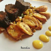 Cilantro, lime and mint marinated seitan with grilled plantains, warm fava bean and roasted corn salsa, topped with a mango coulis. at Great Sage in Clarksville