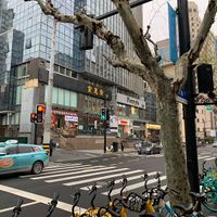 Outside. The restaurant is below the yellow letters (above traffic light )  at Huì Yuán Sù Shí Fāng 慧缘素食坊 Lotus Vegan in Shanghai