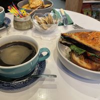 Great coffee and the cheese and leek sandwich pictured in the background (vegetarian)  at Loafley Bakery & Deli Co in Tenby