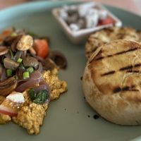 VEGGIE SCRAMBLED EGG WITH TOASTED ENGLISH MUFFINS AND SIDE OF FRUITS  at Aubrie's Plant-Based Cuisine in El Nido
