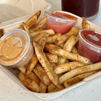 Zatar seasoned fries with all the vegan sauces  at Uumami Food Cart in Eugene