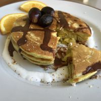 Pandan pancake stack with pineapples, coconut whipped cream, choco sauce and some fruit 😋  at O Baba Vegan in Denpasar