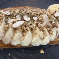 PB toast with banana, nuts, and seeds. Delicious! Bread is vegan. Need to modify standard “pb mousse” to straight pb. But the ppl there are wonderful and willing to modify 🥰 at Milk & Honey  in Surfside Beach