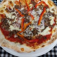 Mozzarella, meat, pepper, onion and tomato pizza at Ristorante Nando Pizzeria in Manresa