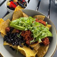 Fresh tortilla chips with black beans, soy chorizo, sliced avocado, fresh fruit on the side Topped with spring mix at Elderwood at the Darling in Visalia