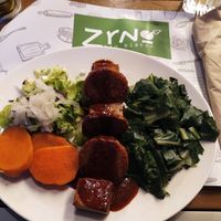 Mega proteine plate: grilled tempeh and farmmade tofu & seitan with BBQ sauce, green vegetables and cooked sweet potato. at Zrno Bio Bistro in Zagreb