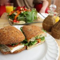 Wholegrain ciabatta with tofu, pesto and salad. In the background is vegan salad with cashews, beets and strawberries. at Xiguela Cafe in Oaxaca