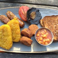 Vegan breakfast: two hash browns, two skin on sausages, half a grilled tomato, large mushroom, three falafel, pot of beans and two (gluten free) toast. at The Reader Cafe in Liverpool