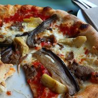 A delicious vegan pizza topped with flavorful artichokes and melted vegan cheese. The artichokes were especially tasty! at Pizzaloriano in San Roque