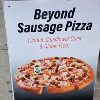 Placard (make sure to ask for vegan cheese with the beyond sausage if you want a vegan pie) at iPizzaNY in New York City