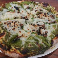 Pizza with vegan cheese, burned crust, and heavy with oil at The Daily Kitchen & Bar in Richmond